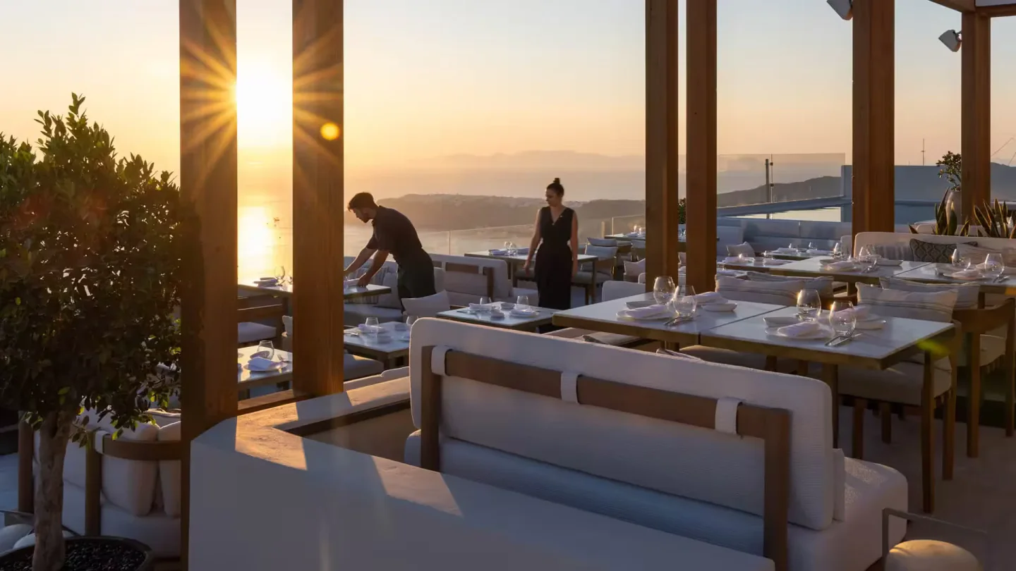 Elegant dining setup at Blu restaurant in Santorini with ocean sunset views and attentive staff.