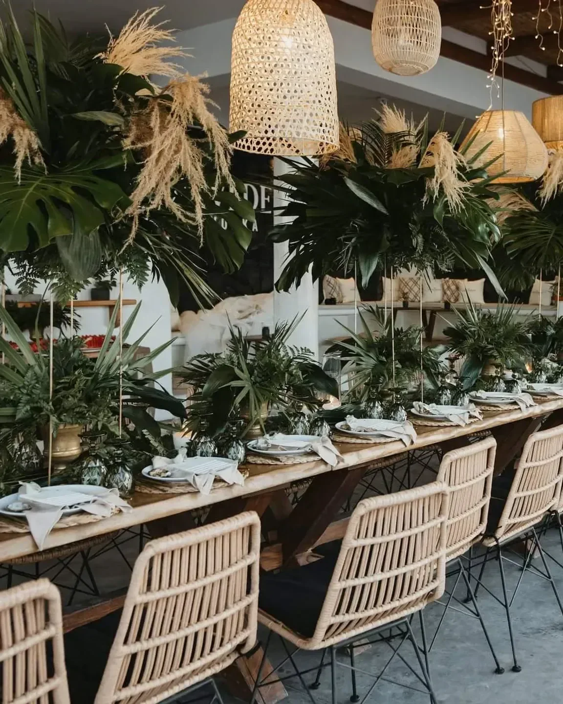 Dining experience at East Breeze restaurant in Santorini, featuring stylish decor and lush greenery.