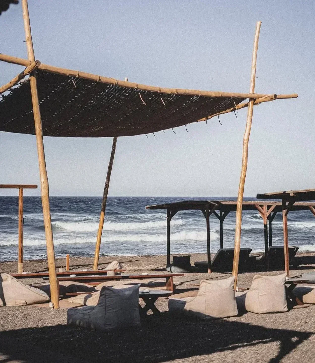 Relaxing beach seating at East Breeze beach club, Santorini, overlooking the Aegean Sea.