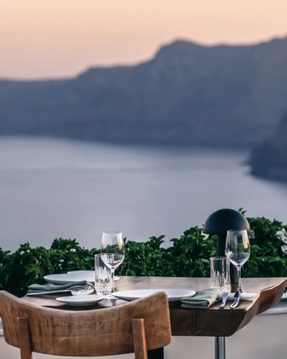 Elegant table setting at NAOS restaurant overlooking the city and sea at dusk